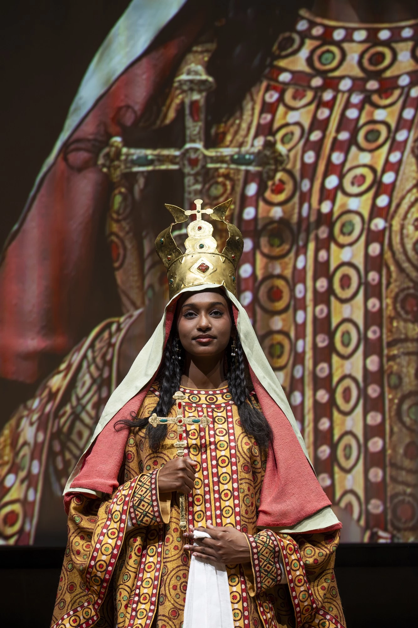 A photo of a model wearing a reconstructed royal costume from Faras, captured during a presentation in Paris.