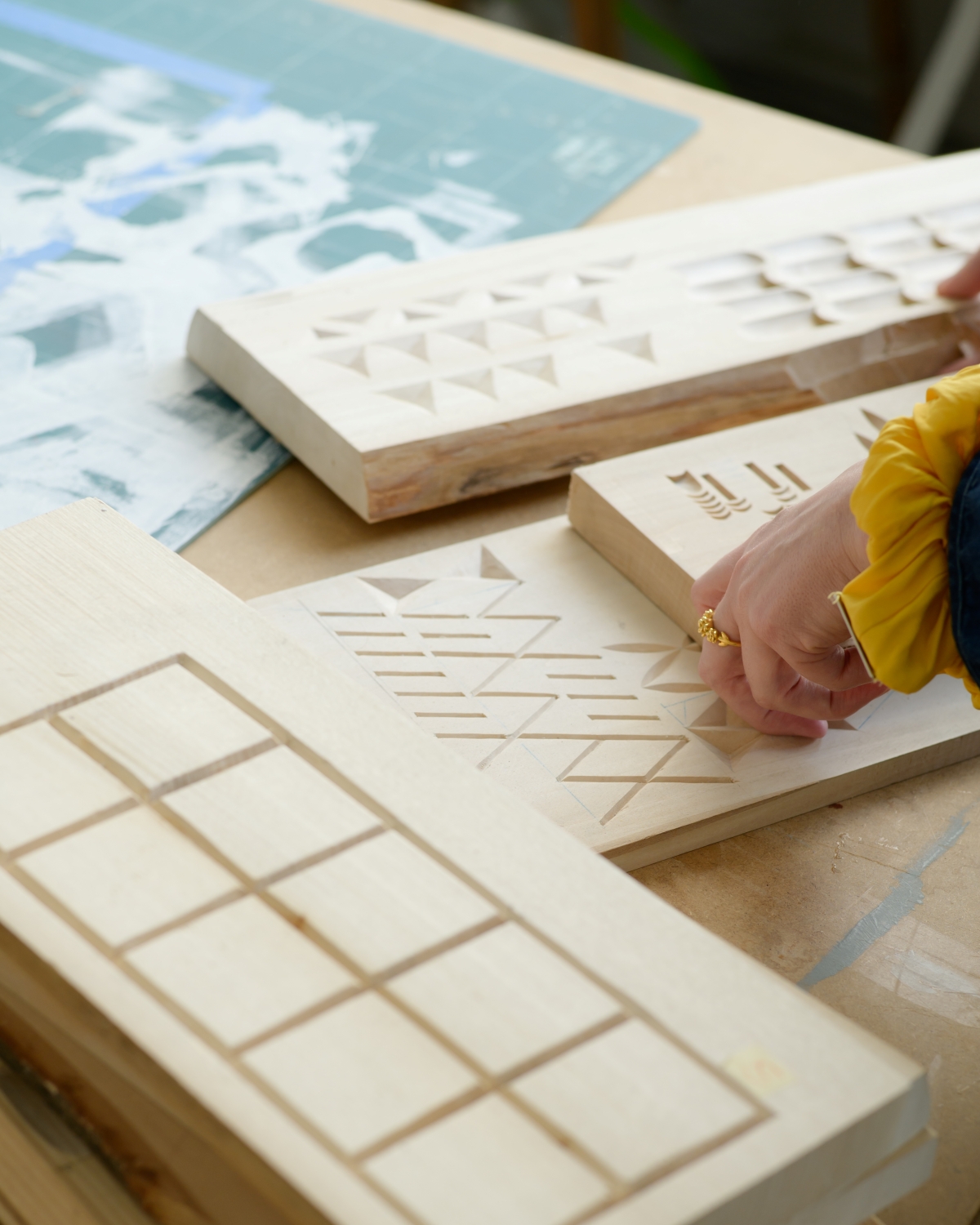 Kilka drewnianych płytek, na każdej wycięty inny geometryczny wzór