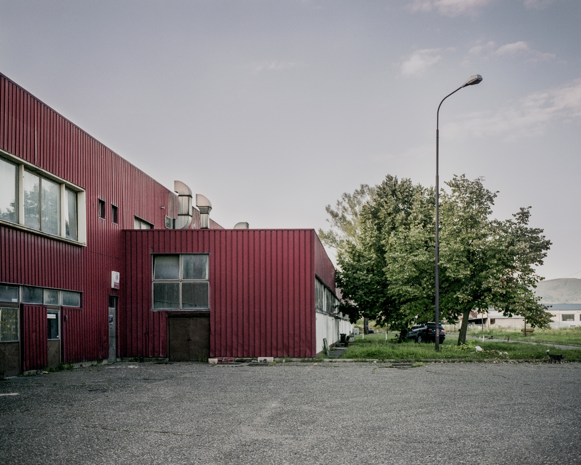 Pusty parking przed budynkiem z czerwonej blachy