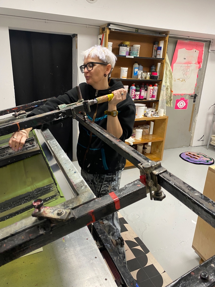 Marta Kwiatek obsługuje maszynę do sitodruku