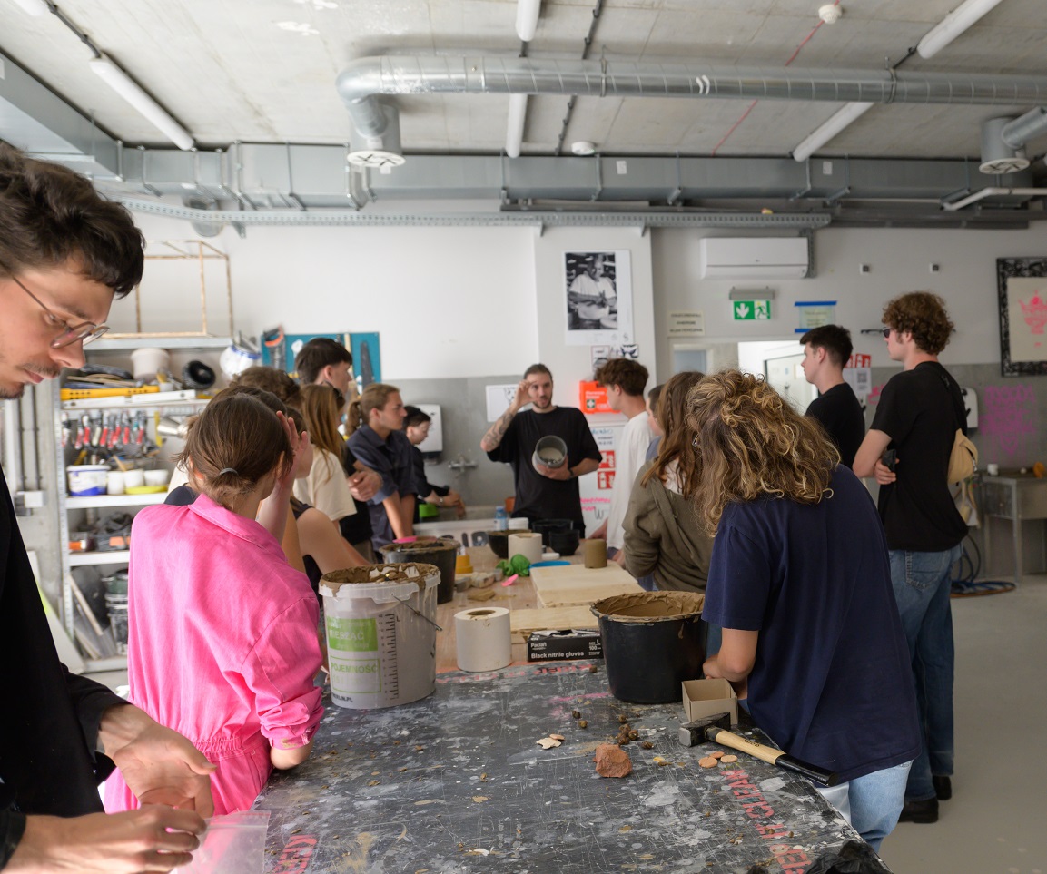 A group of students at a work table in a Ceramics Studio.