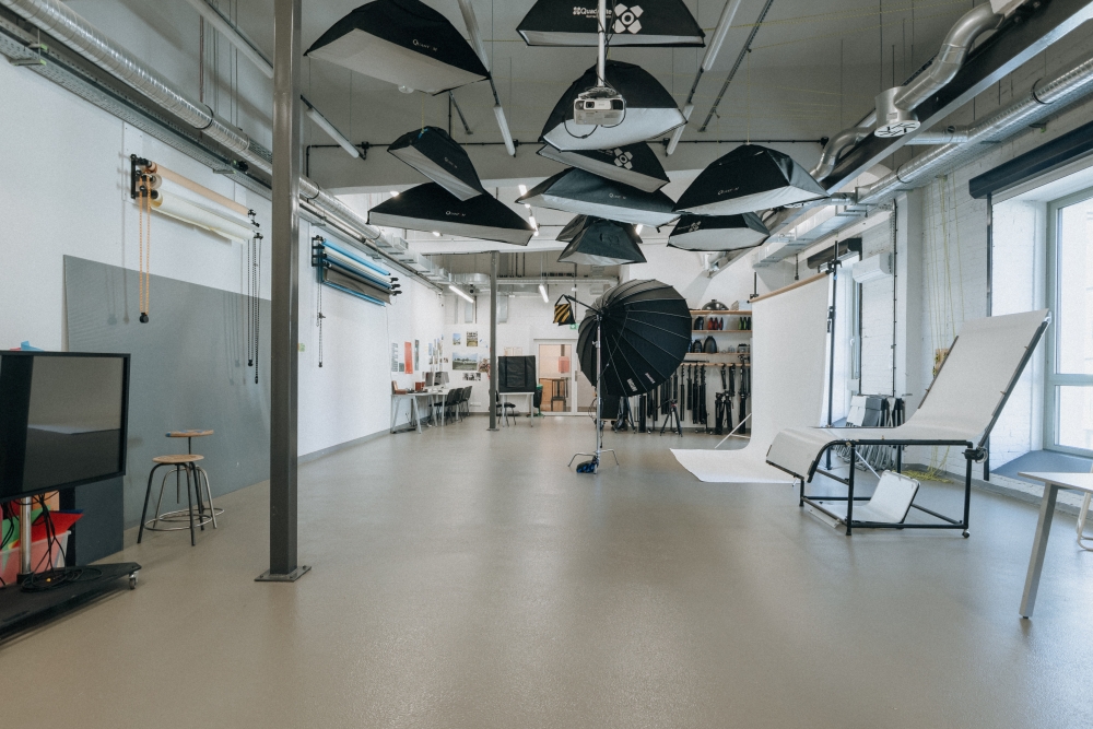 Interior of a photo and video studio with various lights suspended from the ceiling.