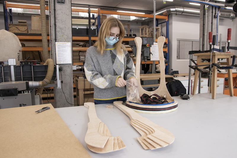 Young girl in woodworking workshop at work table
