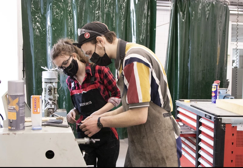 A man and a woman working in a Metal Workshop