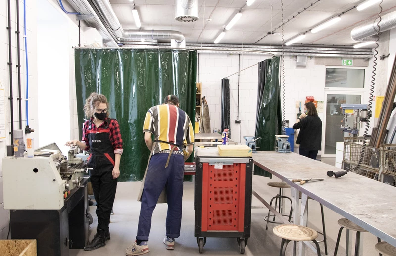 A man and a woman working in a metal workshop shop