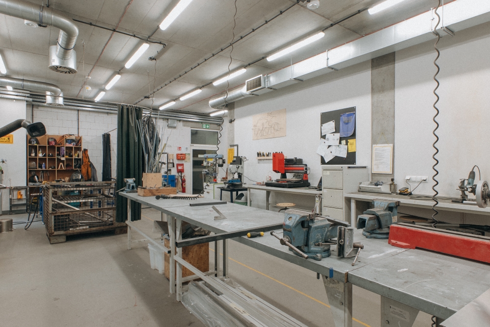 Wnętrze warsztatu ślusarskiego, widok na maszyny.