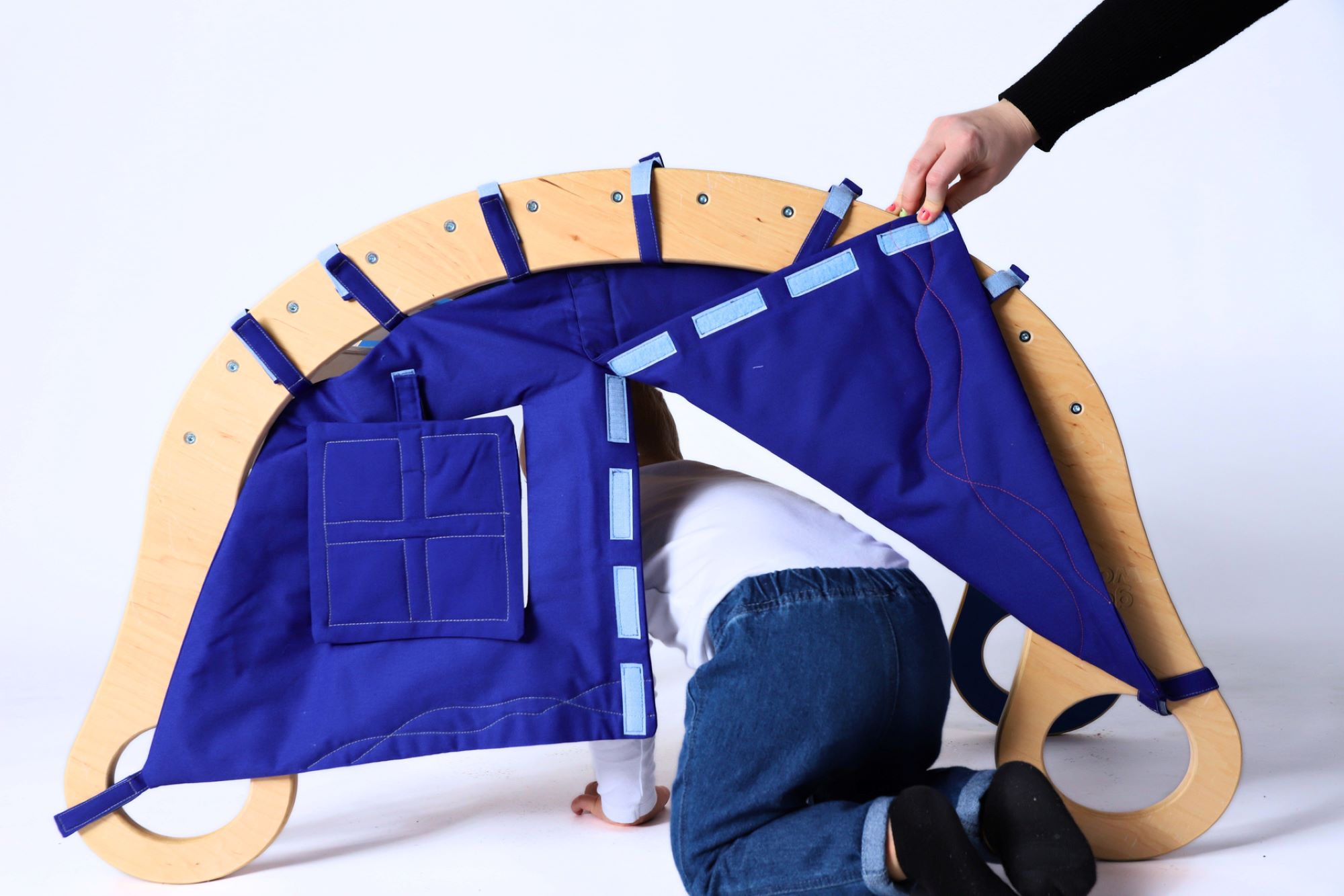 Rocker with accessories transforming it into a tent; a small child entering through the tilted entrance