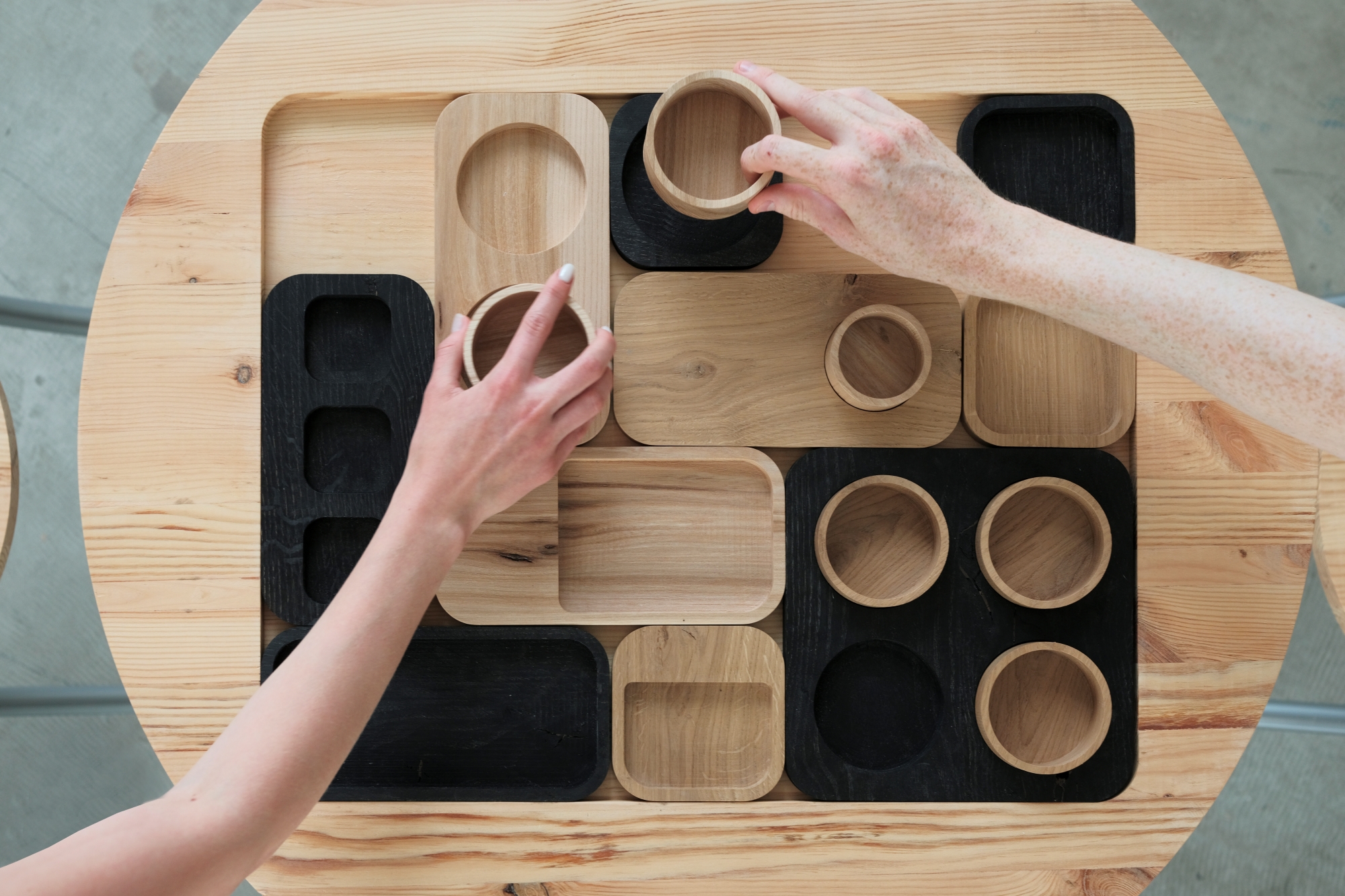 Top view of a wooden tabletop and wooden dishes designed by Milena Jankowska