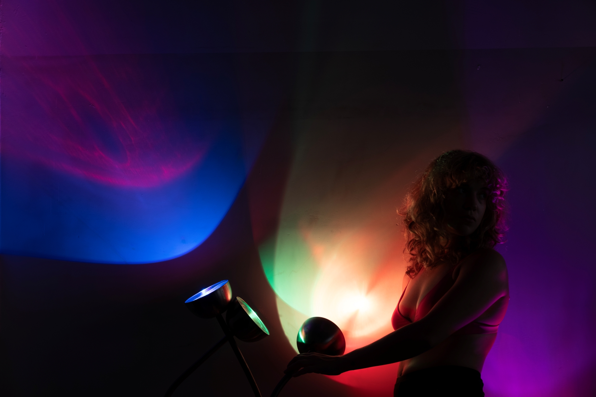 A woman's silhouette illuminated by subdued colored light.