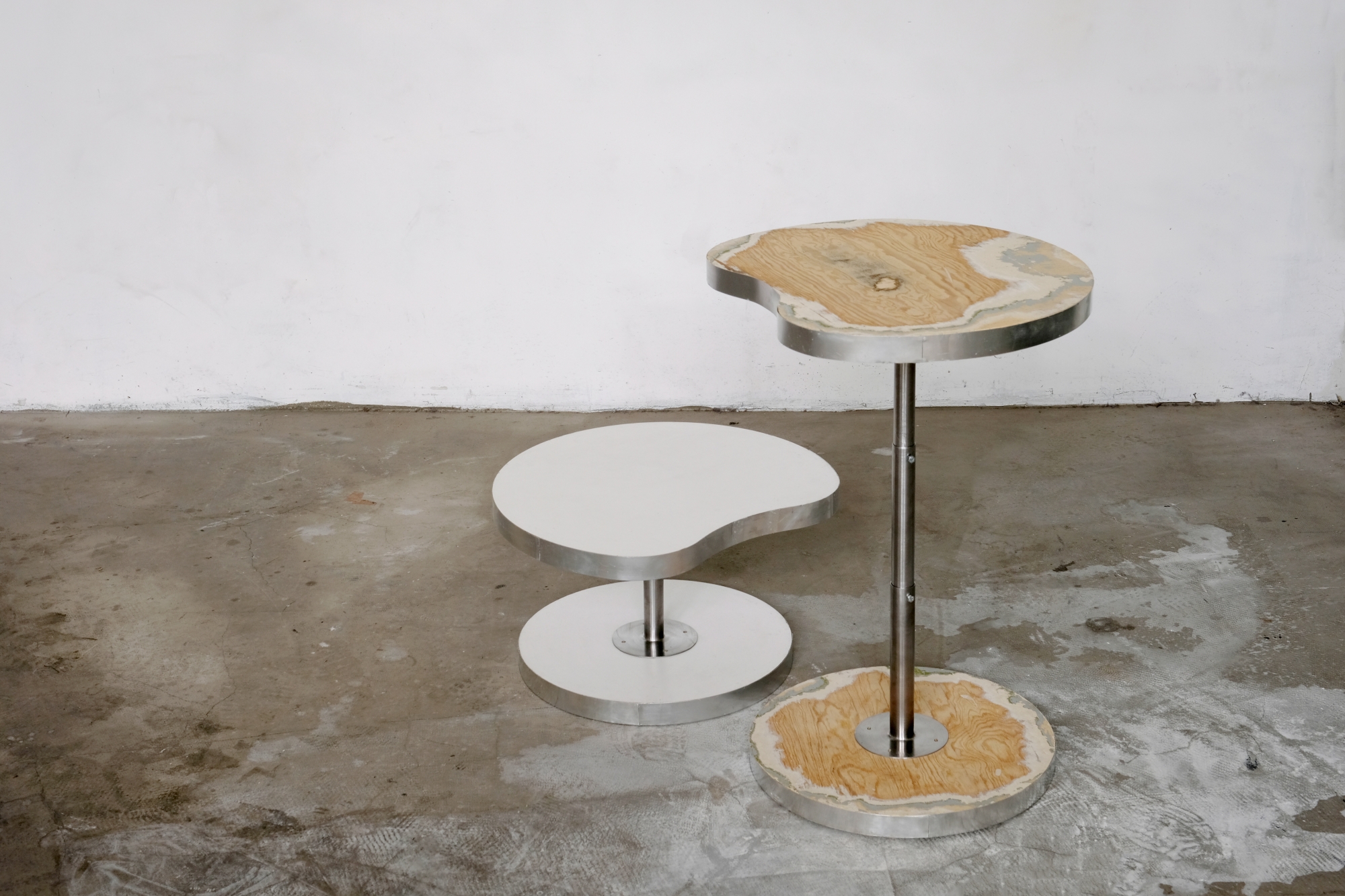 Two tables with kidney-shaped tops designed by Julia Drumlak: one low and one high.