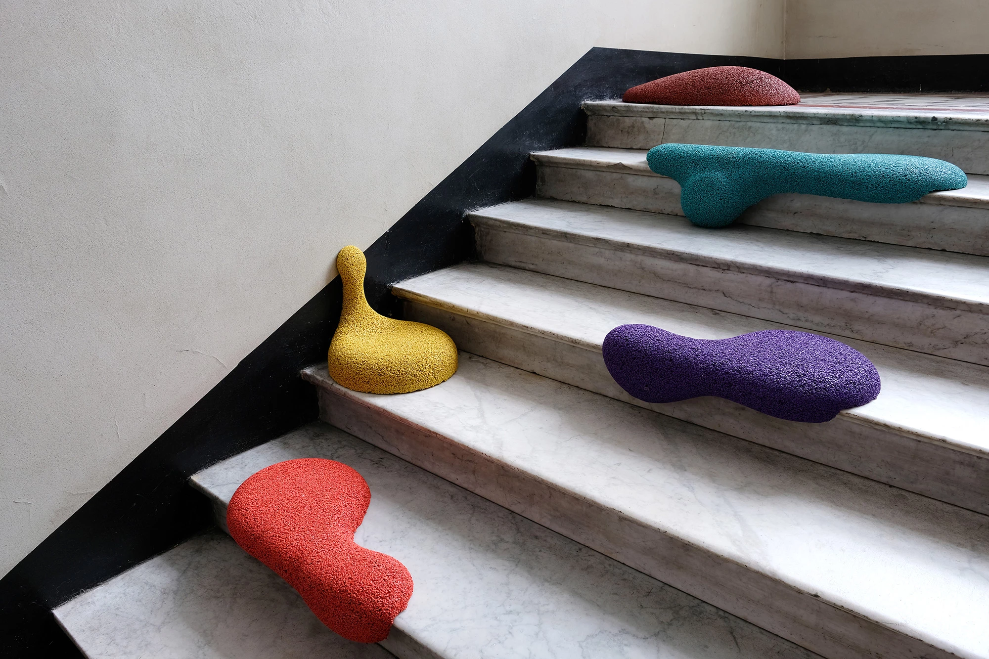 A set of 5 colorful irregular shaped overlays that serve as seats in the urban space. They are placed on the stairs. The final project of Natalia Tarnowska, graduate of the School of Form.