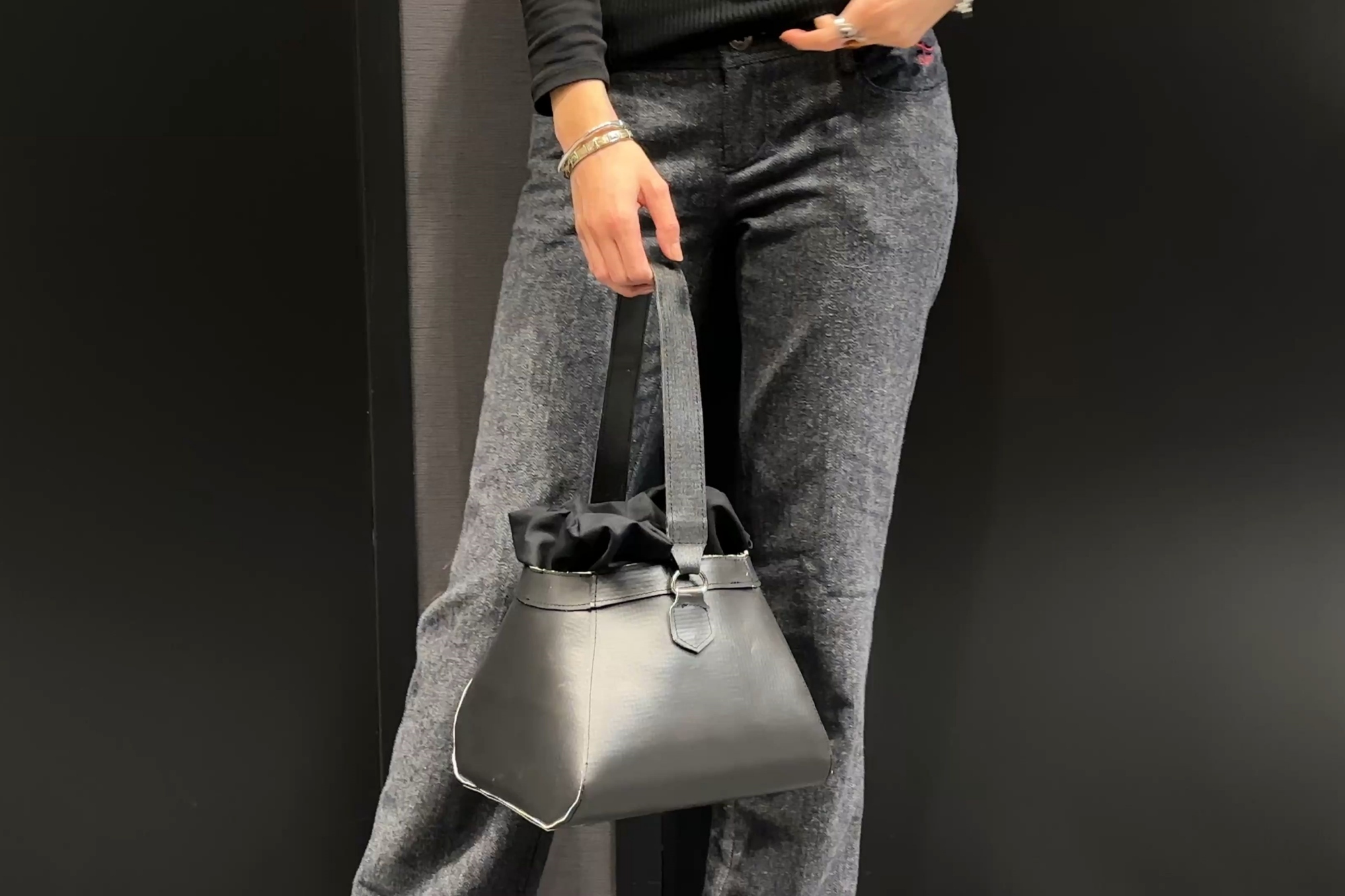 Model wearing a handbag made of roofing membrane