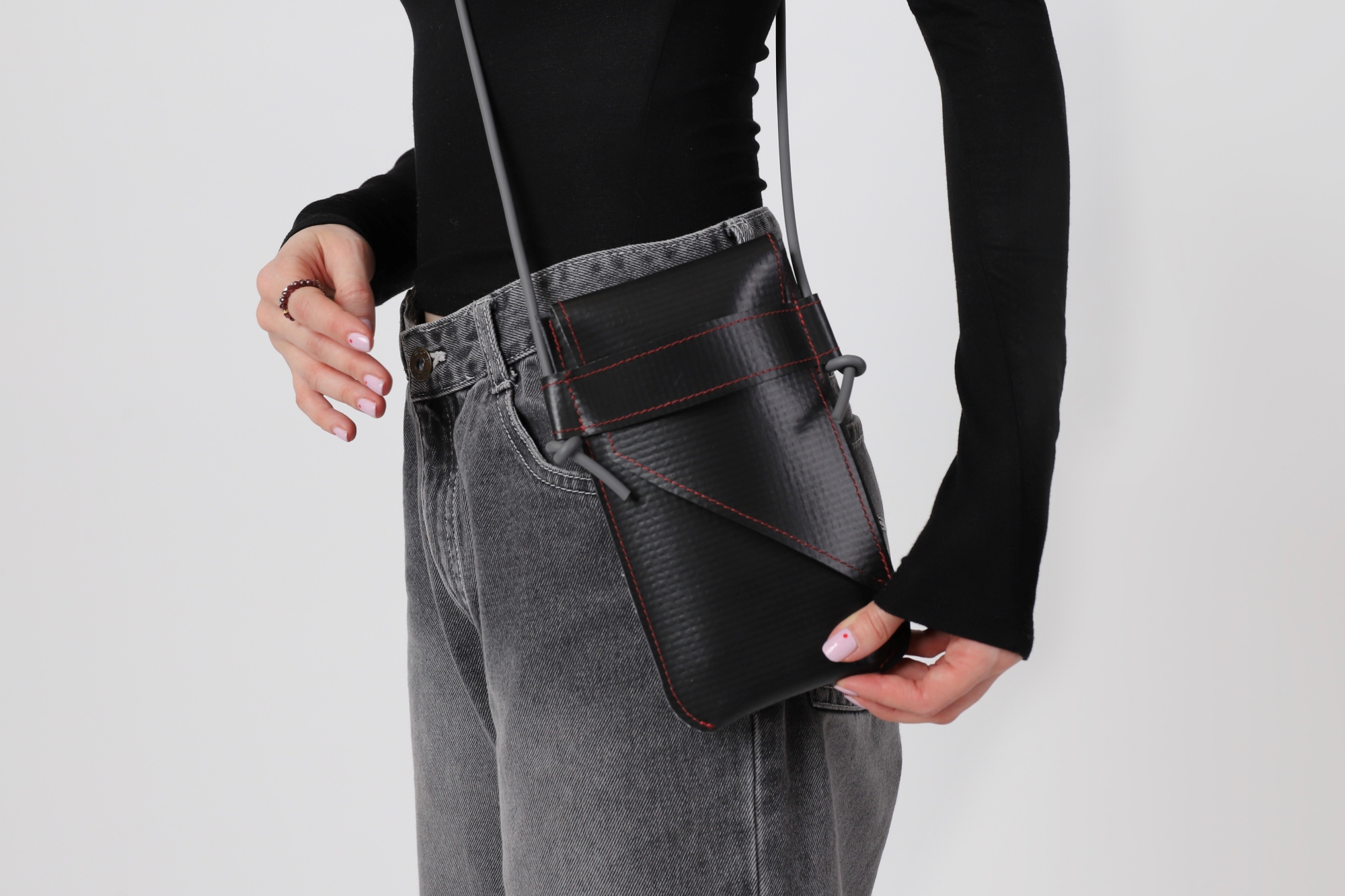 Model wearing a small shoulder bag made of roof membrane.